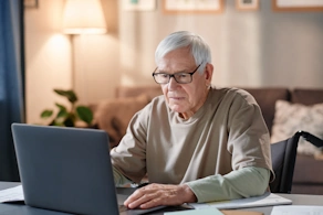 Life Assure Senior Researching On Computer At Home Hero